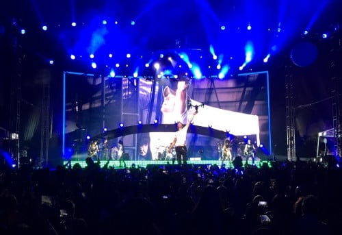 In this photo provided by Francis Ramsden, Enrique Iglesias grabs a drone onstage during a concert in Tijuana, Mexico on Saturday, May 30, 2015. A representative for the singer says in a statement to The Associated Press that Iglesias was "semi-treated" offstage after his fingers were sliced when he grabbed the drone. During live shows, Iglesias sometimes grabs a drone to show the audience a "point of view" angle. (Francis Ramsden via AP)