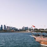 View of Doha skyline with a traditional dhow boat on the waterfront